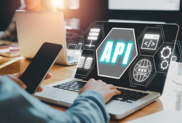 API - Application Programming Interface, Woman using laptop computer with VR screen API icon on office desk, Software development tool, modern technology, internet and networking concept.